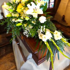 Casket spray with colours of green, yellow and white - gladioli, oriental lilies, crysanthemums and gypsophlia