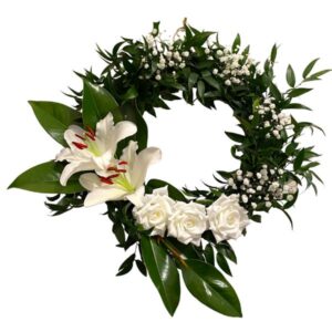 Elegant white and green wreath with roses and oriental lily, gypsophlia and magnolia leaves