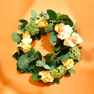 Pretty wreath for a gentle lady, apricot coloured roses with queen anne's lace with large oval green leaves