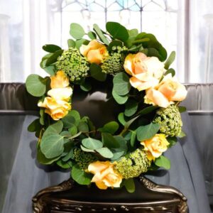 Picture of leafy wreath with apricot roses and delicate queen anne's lace flowers