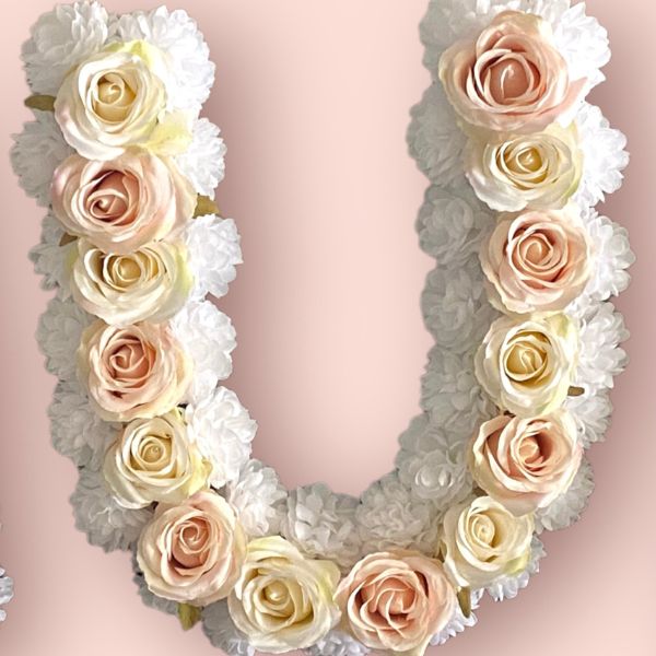The letter U with artificial pink cream and white flowers
