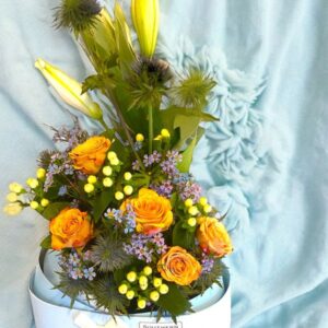 Blue, yellow and white flowers encased in a baby cradle box - a gift to say congratulations