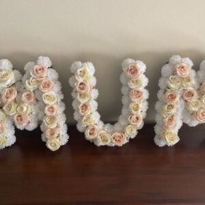 Mum in three seperate letters, artificial white flowers with apricot pastel roses approximately fifty centimetres in height